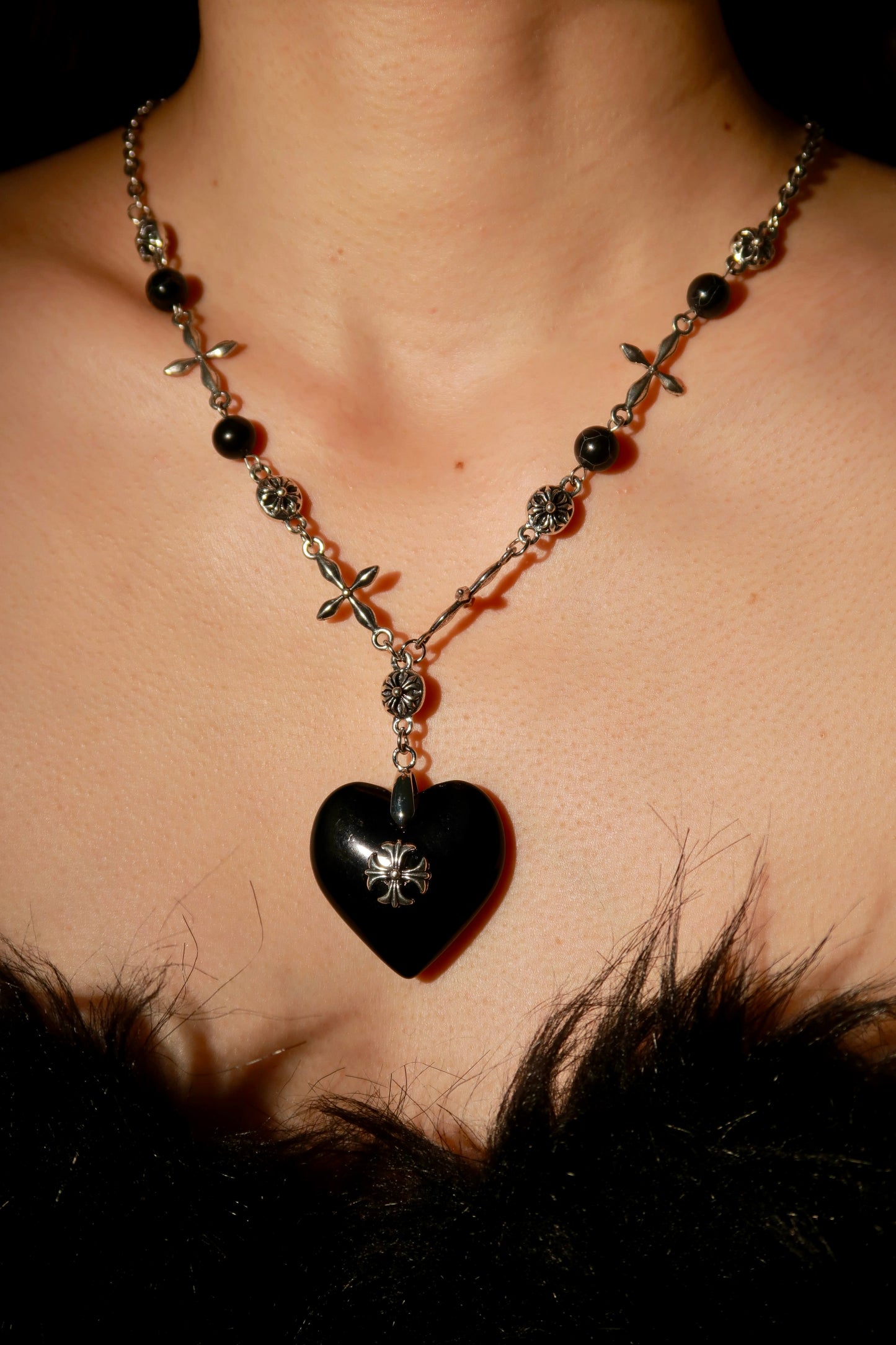 Necklace with a heart-shaped pendant worn by a person
