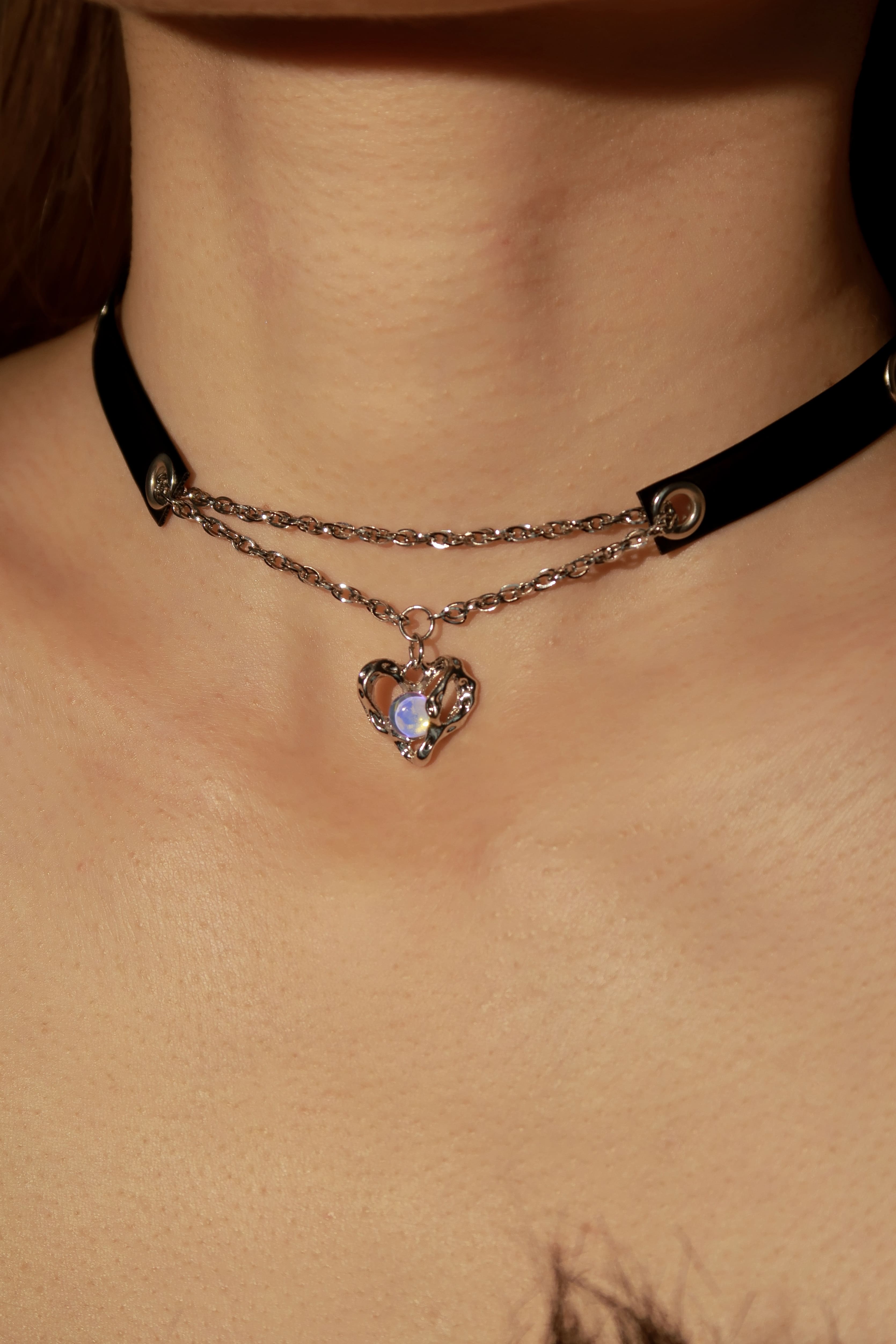 Necklace with a heart-shaped pendant on a person's neck