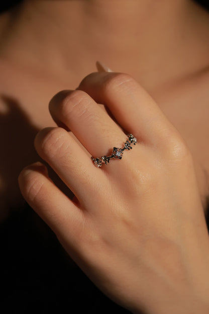 Close-up of a hand wearing a decorative ring with a blurred background