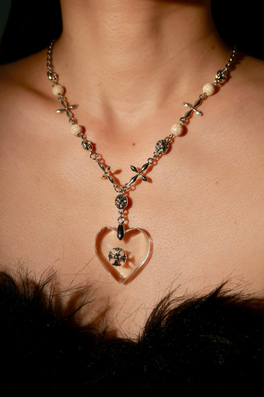 Necklace with a heart-shaped pendant worn by a person