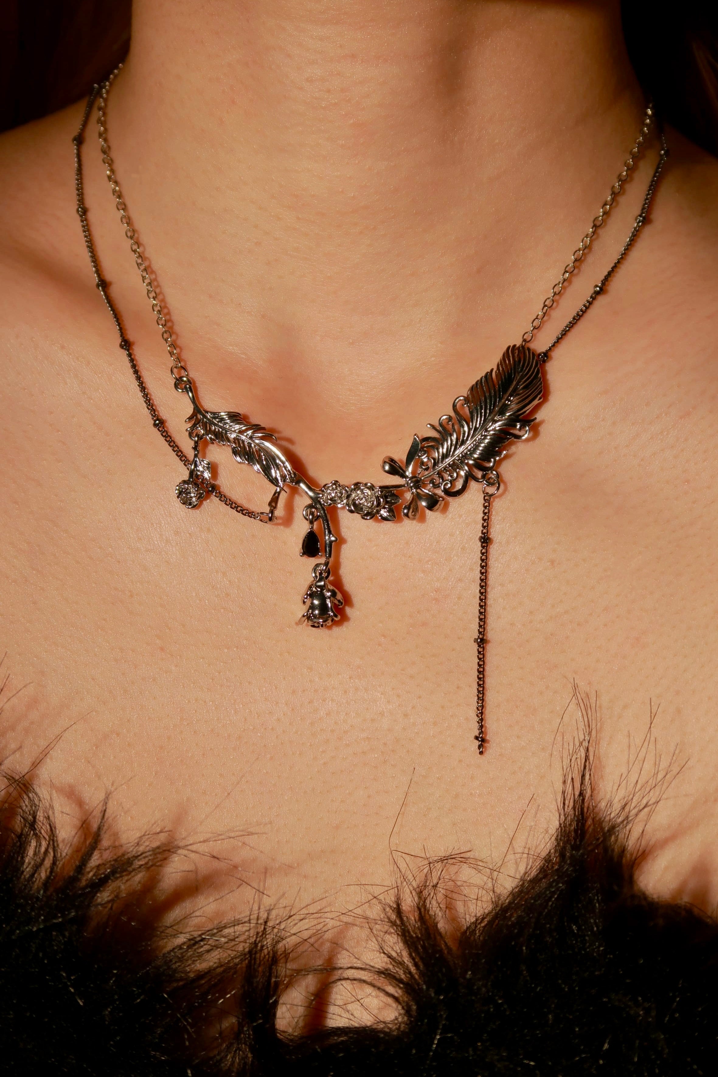 Necklace with feather designs on a person's neck