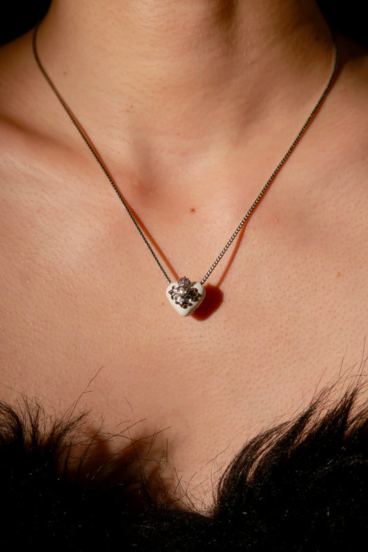 Necklace with a heart-shaped pendant on a person's neck