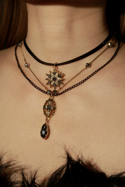 Close-up of a person wearing multiple necklaces with intricate designs.