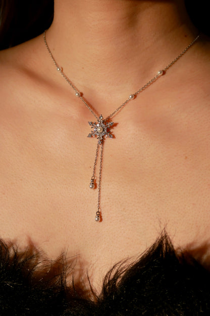 Necklace with a star-shaped pendant worn by a person, with a blurred background.