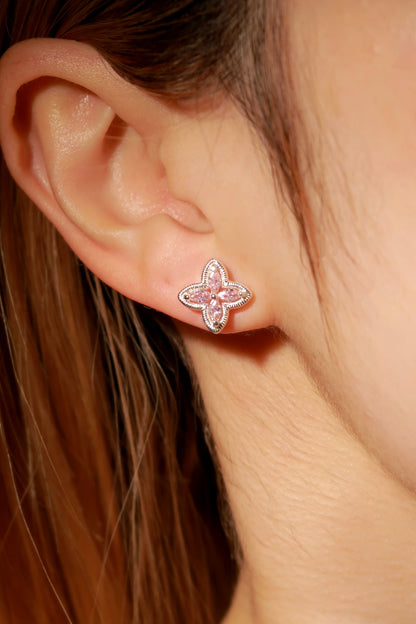 Close-up of a person wearing a pink butterfly earring.