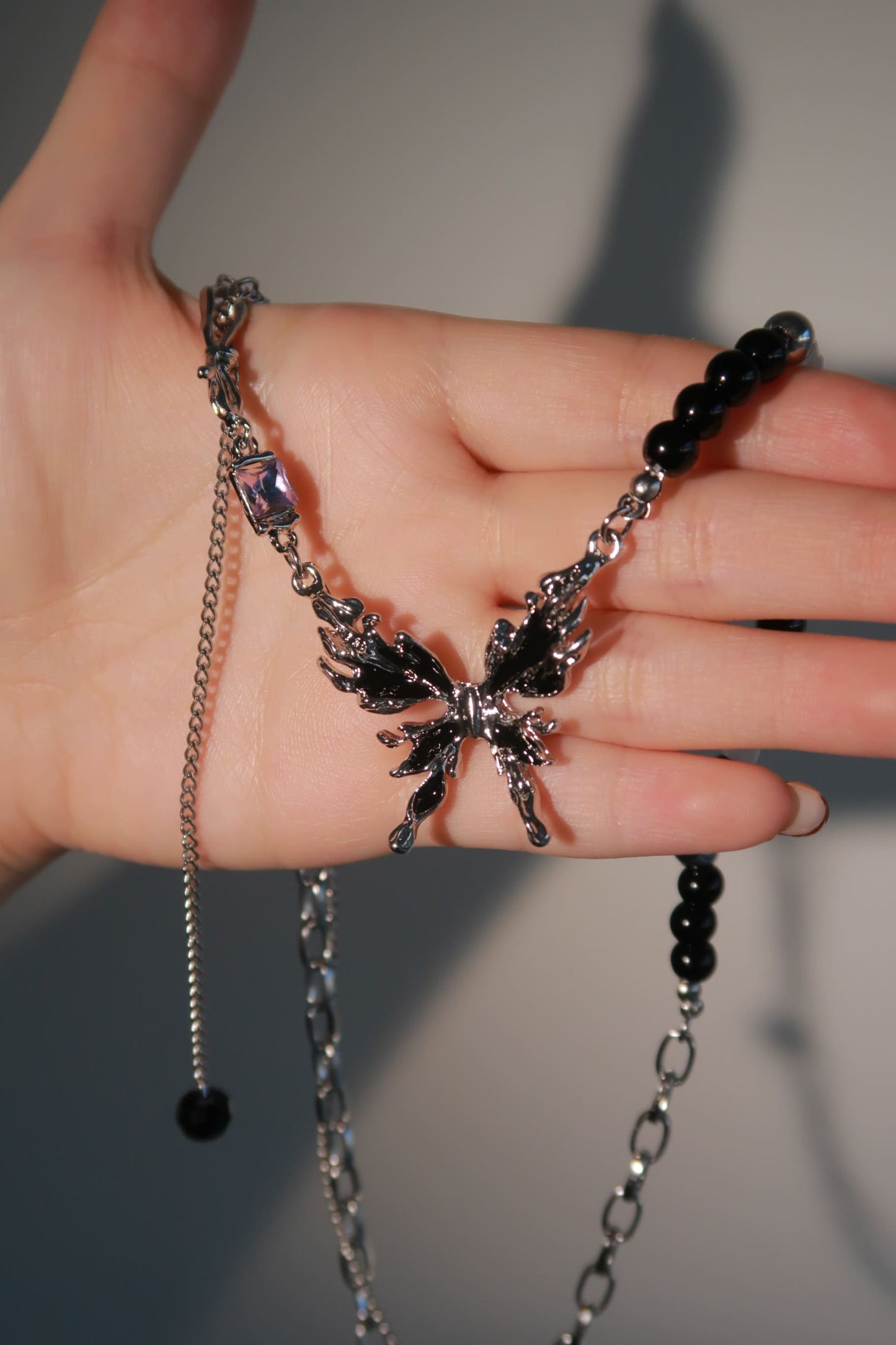 Beaded Nocturne Butterfly Necklace holding on hand