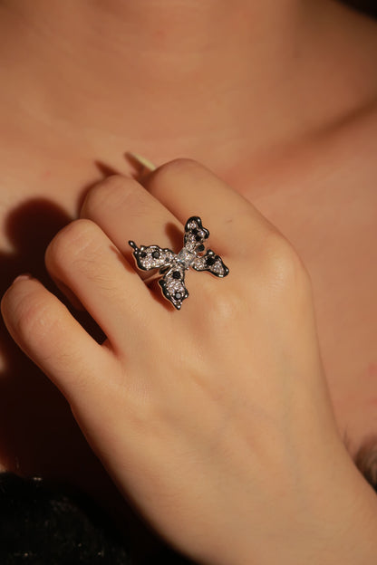 Close-up of a hand wearing a decorative ring with a blurred background