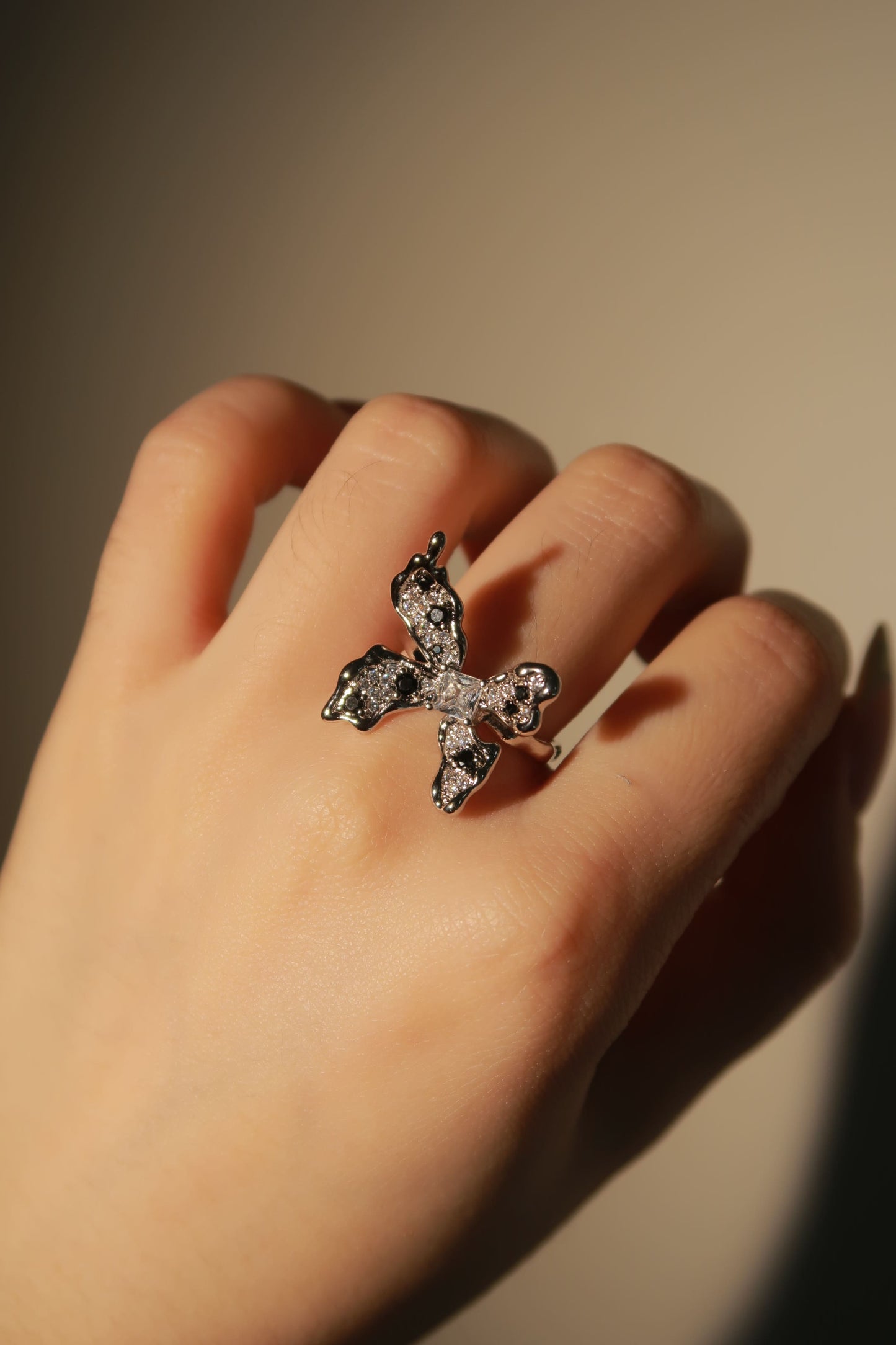 Hand wearing a decorative ring with a blurred background