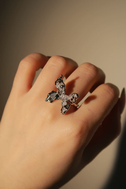 Hand wearing a decorative ring with a blurred background